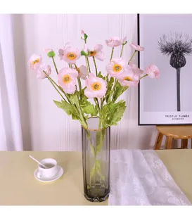 Primer plano de flores de seda de amapola artificial rosa con tallos flocados en jarrón