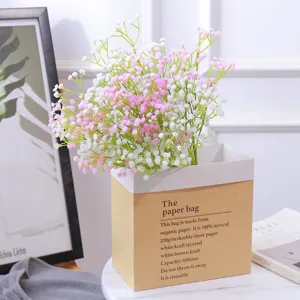 Primer plano de paniculata artificial rosa y blanca en una bolsa de papel kraft minimalista