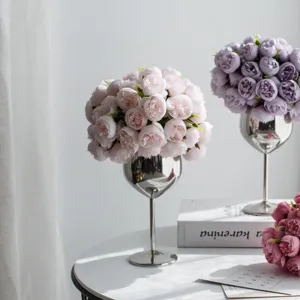 Elegante künstliche Rosen in silbernen Kelchvasen für eine stilvolle Heimdekoration.