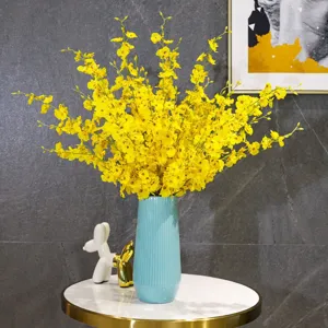 Leuchtend gelbe künstliche Tanzorchideen in blauer Vase für stilvolle Dekoration