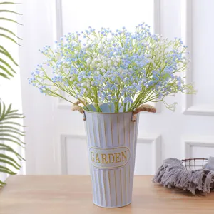 Hermoso ramo de paniculata artificial azul y blanca en un cubo de metal estilo vintage