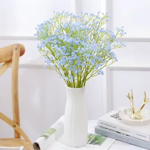 Vista detallada de un ramo de paniculata artificial azul claro en un jarrón estriado