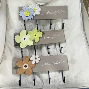 Detail showing three floral wall-mounted wooden coat racks with four hooks each.