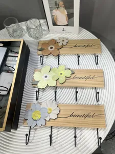 Detailed view of wooden wall coat racks featuring decorative flowers and black metal hooks