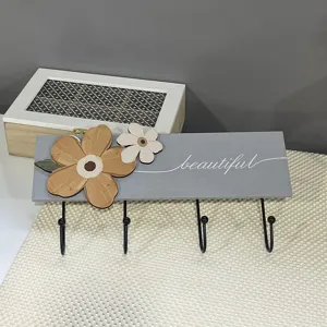 Close-up of a gray wooden wall-mounted coat rack featuring 3D flowers and beautiful text
