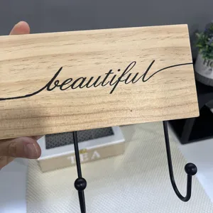Detailed view of a handmade solid wood wall hook with decorative 'beautiful' script