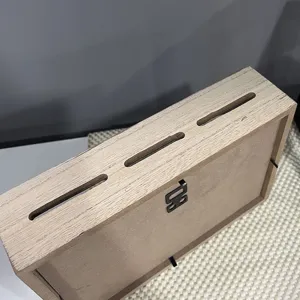 Rückansicht einer hölzernen Spardose mit 3 Schlitzen und Aufhängung am Gehäuse