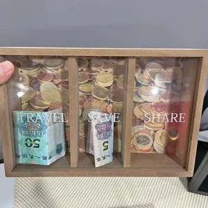 Nahaufnahme einer Holzspardose mit drei Fächern, beschriftet mit Travel Save und Share