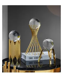 Luxury modern crystal ball ornaments with gold metal stands on a black marble table.