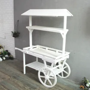Vue détaillée d'un chariot à fleurs rustique en bois blanc avec toit pour magasin