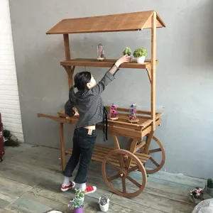 Chariot à fleurs rustique en bois avec toit et roues pour une décoration de vitrine