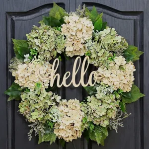 Close-up of artificial hydrangea flower wreath with wooden hello sign on black door