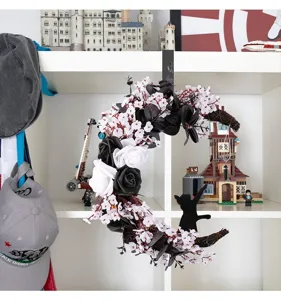 Detailed view of Halloween moon wreath with black and white roses and cat silhouette
