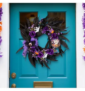 Close-up of Halloween wreath with black leaves, purple roses and spooky ghost accents