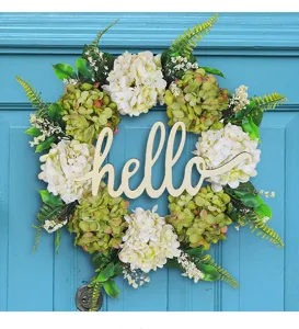 Detailed view of artificial hydrangea wreath featuring a wooden 'hello' greeting sign.