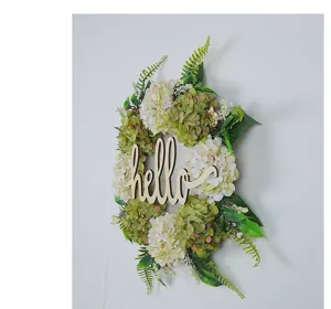 Detailed side view of artificial hydrangea wreath with a wooden hello sign on a wall