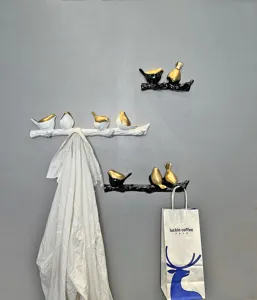 Close-up detail of creative bird branch wall hooks used for hanging a shirt and paper bag