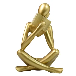 Figura moderna de pensador abstracto dorado leyendo un libro adorno de resina para el hogar