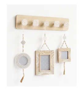 Houten wandkapstok in boho-stijl met decoratieve fotolijsten met witte patronen