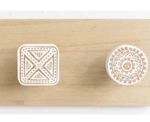 Gedetailleerde weergave van decoratieve witte houten wandhaken met tribale patronen