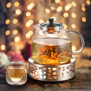 Detail view of blooming tea in glass teapot on stainless steel warmer with candle