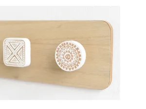 Detailweergave van decoratieve witte houtsnijpatronen op een minimalistische kapstok