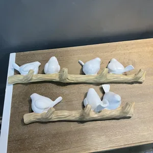 Two creative decorative wall hooks shaped like birds sitting on a tree branch