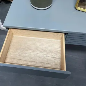 Macro detail view of an open wooden drawer inside a minimalist gray vanity dressing table