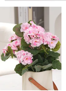 Vue détaillée d'un bouquet d'hortensias roses artificiels dans un vase crème élégant