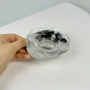 Detalle de frutero de cristal con borde ondulado y base de acero