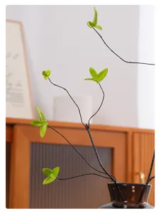 Close-up of artificial dry tree branches with realistic green fabric leaves for home decor