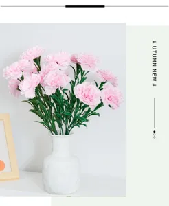 Detailed macro view of pink artificial carnations in a minimalist white ceramic vase