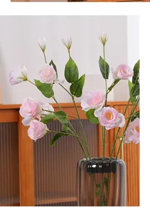 Close-up of elegant pink artificial lisianthus flowers in a stylish grey glass vase