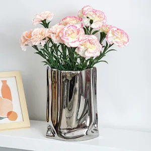 Elegant pink artificial carnations in a modern silver metallic vase for home decor