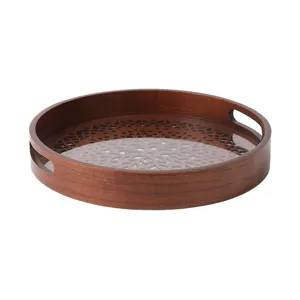 Round wooden serving tray with hollow carved pattern and glass bottom for home decor use