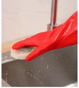 Primer plano de guante doméstico rojo impermeable limpiando fregadero de acero