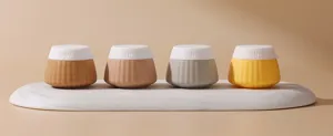 Detailed view of four colorful silicone travel bottles on a marble tray