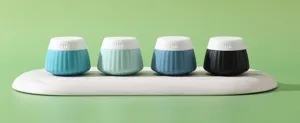 Row of colorful silicone travel dispensing bottles on a white marble display tray