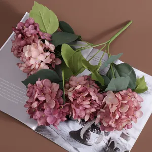 Detail van vijfkops kunsthortensia bloemen in vintage roze op een bruine achtergrond