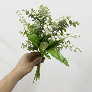 Ramo artificial de eucalipto y lirio de los valles para decoración del hogar en la mano