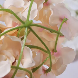 Close-up detail of artificial pink flower wall backdrop, showing realistic fabric petals and stems.