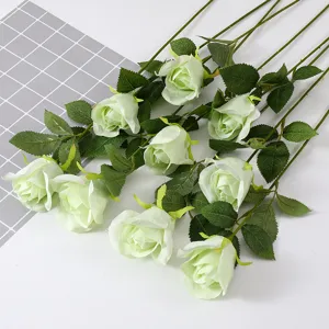 Detailed view of light green artificial snow mountain roses with lifelike silk petals