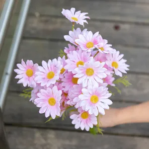 Detaillierte Nahaufnahme eines künstlichen Gänseblümchenstraußes in Rosa von Hand