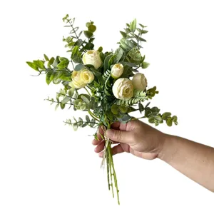 Elegante ramo artificial de eucalipto y camelia sostenido a mano para decorar el hogar