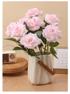 Realistic pink artificial roses with curled petals displayed in a stylish modern white vase