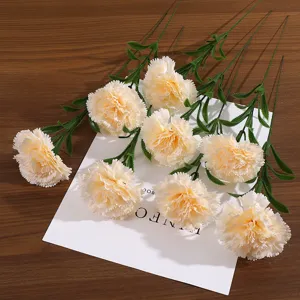Vue détaillée d'oeillets artificiels crème avec des tiges vertes sur un décor en bois.