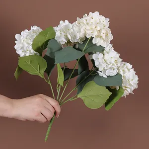 Detailopname van een handbediend boeket witte kunstmatige hortensia's met 5 koppen