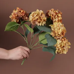Close-up van een vijfkops kunsthortensiaboeket in een warme vintage bruine kleur