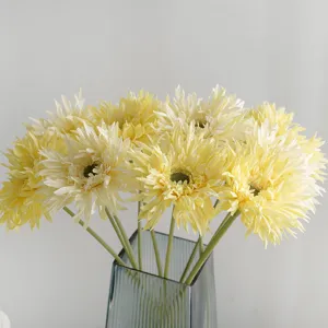 Fresh artificial cream Gerbera daisy flowers in a blue glass vase for home decor