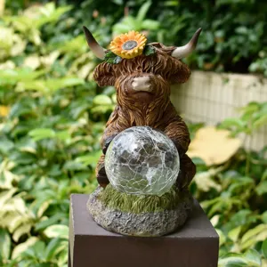 Highland cow solar powered resin garden statue featuring a sunflower and crackle glass ball